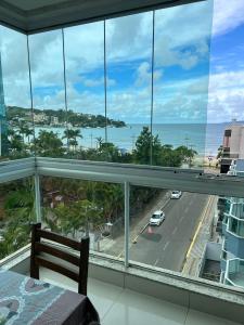 1 dormitorio con vistas al océano desde el balcón en Residencial Neli Passos, en Itapema