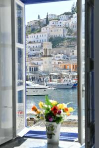 a window with a view of a harbor with boats at Delfini Hotel in Hydra