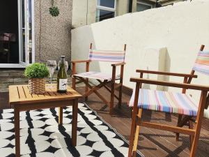 two chairs and a table with a bottle of wine on a patio at Sunderland Stays, Rose, City Centre, HS Wi-Fi, Smart TV & Free Parking in Sunderland