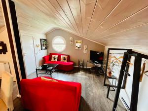 a living room with a red couch and a ceiling at poplar lofts & apartments karavouzi in Prinos