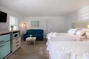 a bedroom with two beds and a blue couch at Lily & Bloom in Myrtle Beach