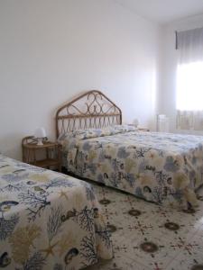 a bedroom with two beds and a window at Don Vito in Racale