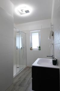 a white bathroom with a sink and a shower at Regina's home in Bari