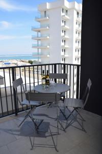 a table and chairs on a balcony with a view of the beach at Regina's home in Bari