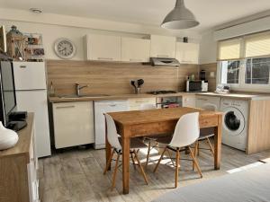 una cucina con tavolo in legno ed elettrodomestici bianchi di Escapade et spa aux gorges du Verdon, spa ouvert juillet et août a La Verdière Altre 13 foto