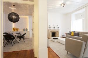 ein Wohnzimmer und ein Esszimmer mit einem Sofa und einem Tisch in der Unterkunft ALTIDO Elegant 3BR Apt with workspace in Chiado in Lissabon