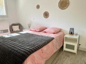 una camera da letto con un letto con lenzuola rosa e un tavolo di Escapade et spa aux gorges du Verdon, spa ouvert juillet et août a La Verdière