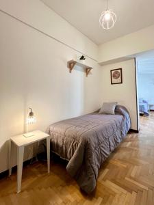 ein Schlafzimmer mit einem Bett und einem Tisch mit einer Lampe in der Unterkunft PH en Playa Grande I hasta 4 personas in Mar del Plata