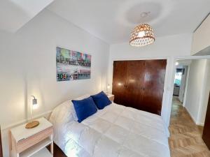 1 dormitorio con cama blanca y cabecero de madera en PH en Playa Grande I hasta 4 personas en Mar del Plata
