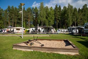 un bac à sable au milieu d'un champ avec des tentes dans l'établissement Sandaholm Camping, Bad och Restaurang, à Årjäng