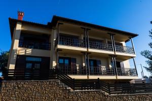 an apartment building with balconies on a brick wall at Helianthus Guesthouse in Ammouliani