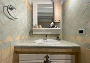 y baño con lavabo y espejo. en [Loft Comodo ed Elegante] • Wi-Fi e Colazione, en Sanluri