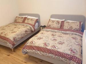 two beds sitting next to each other in a bedroom at London Luxury 2 Bedroom Flat Sleeps 8 free parking in East Barnet