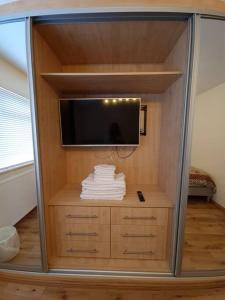 een kamer met een tv en een dressoir met handdoeken bij London Luxury 2 Bedroom Flat Sleeps 8 free parking in East Barnet