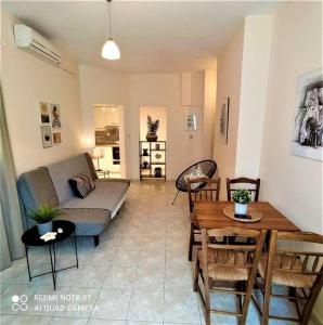 a living room with a couch and a table at Anastasia's Garden - Yellow Apartment in Moúdhros