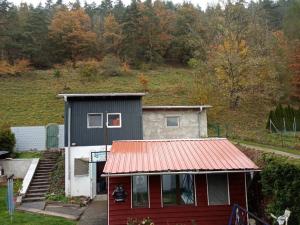 mały domek z czerwonym blaszanym dachem w obiekcie Kleines Studio mit Gartenzugang w mieście Milbitz