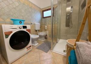 a bathroom with a toilet and a washing machine at [Loft Comodo ed Elegante] • Wi-Fi e Colazione in Sanluri