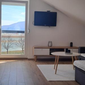 a living room with a flat screen tv on the wall at Vikendica Bruše in Jaklići