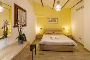 1 dormitorio con paredes amarillas y 1 cama con 2 toallas en Il Tramonto Holidays, en Trevi