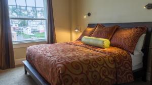 a bedroom with a bed with a large window at Hotel Elliott in Astoria, Oregon