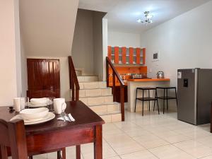eine Küche und ein Esszimmer mit einem Tisch und einem Kühlschrank in der Unterkunft La Condamine Apart Hotel in Iquitos