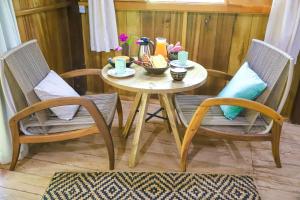 POUSADA BAWARY في سائو غابريل دا كاشويرا: طاولة صغيرة عليها كرسيين وطاولة عليها مشروبات