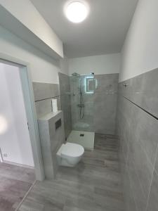 a bathroom with a white toilet and a shower at Ferienwohnung Polnische Ostseeküste OceanHome66 b in Kołobrzeg