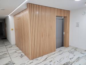 a wooden elevator door in a room with marble floors at Ferienwohnung Polnische Ostseeküste OceanHome66 b in Kołobrzeg