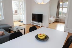 a living room with a table with a bowl of bananas on it at Scandi-Hygge Seaside House - only 10mins to Copenhagen in Charlottenlund
