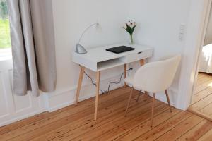 Habitación con ventana y escritorio blanco con 2 sillas. en Scandi-Hygge Seaside House - only 10mins to Copenhagen en Charlottenlund