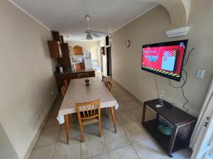 a dining room with a table and a flat screen tv at Casa Barrio Cooperativo Villa Maria in San Juan