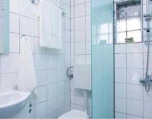 een badkamer met een douche, een toilet en een wastafel bij Lena Apartments 3 in Potos +11 foto's