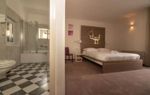 a bedroom with a bed and a bathroom with a toilet at Slavija Culture Heritage Hotel in Split