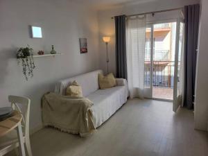 sala de estar con sofá blanco y ventana en Apartamento a 100 m de la playa! en Torroella de Montgrí