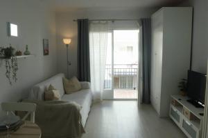 sala de estar con sofá blanco y ventana en Apartamento a 100 m de la playa!, en Torroella de Montgrí