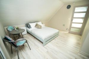 a bedroom with a bed and a table and a chair at CZARDASZ in Krasnobród