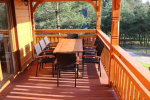 a wooden deck with chairs and a table on it at CZARDASZ in Krasnobród
