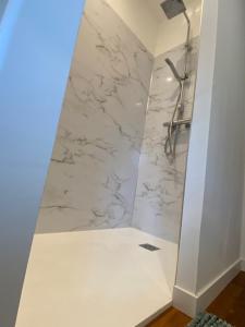 bagno con doccia e pareti in marmo bianco di Myaka©Appartement Fontana a Cholet