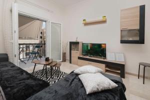 een woonkamer met een bed en een flatscreen-tv bij M&R HOME in Mantoúkion