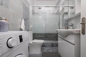 a white bathroom with a toilet and a sink at M&R HOME in Mantoúkion