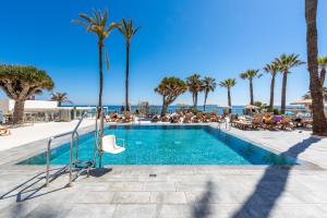 - une piscine avec des palmiers et l'océan dans l'établissement WintowinRentals Apartamento Privado en Ocean House, à Torremolinos