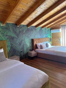 a bedroom with two beds and a tropical wallpaper at Kingfish restaurant & boutique hotel in Patog