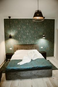 a bedroom with a white bed with a green wall at ARINI WHITE HOUSE in Sibiu
