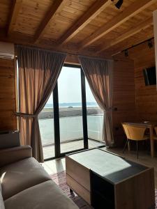 a living room with a couch and a large window at Kingfish restaurant & boutique hotel in Patog