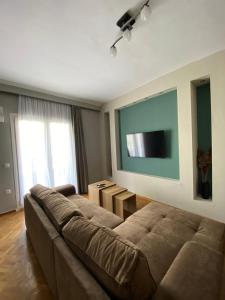 sala de estar con sofá y TV de pantalla plana en Gnaios penthouse, en Tesalónica