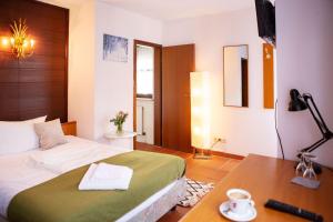 een slaapkamer met een bed, een bureau en een televisie bij Hotel Sofra in Fürth