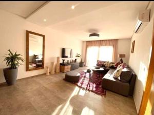 un soggiorno con divano e specchio di Lovely 2 - bedroom - apartment in the heart of Marrakech a Marrakech