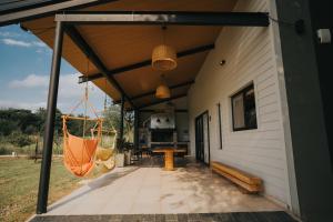 an outdoor patio with a hammock and a house at Casa Brunia Lago Los Molinos in Villa General Belgrano