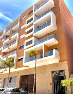 a building with a palm tree in front of it at Lovely 2 - bedroom - apartment in the heart of Marrakech in Marrakesh