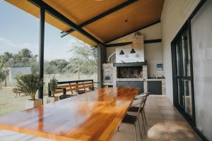 una gran mesa de madera en una habitación con chimenea en Casa Brunia Lago Los Molinos en Villa General Belgrano